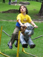 Un enfant joue sur un éléphant en bois.