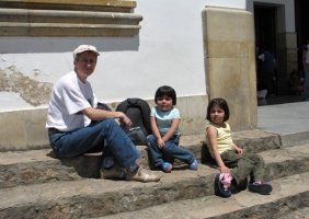 Une femme et deux enfants assis sur les marches d'un escalier.