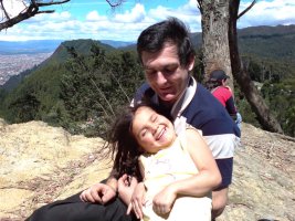 Un homme est assis et tient un enfant dans les bras.