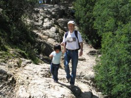Une femme marche avec un enfant dans les rochers.