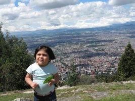 Un enfant se tient debout avec la vue sur la ville en arrière-plan.