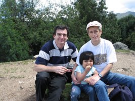 Deux adultes et un enfant sont assis sur une pierre.