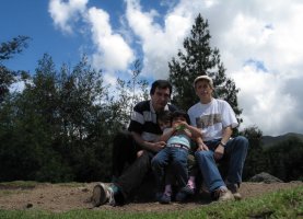 Deux adultes et deux enfants sont assis sur une pierre.