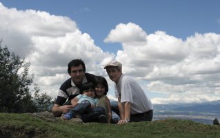Deux adultes et deux enfants sont assis dans l'herbe.