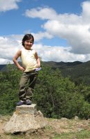 Un enfant se tient debout sur une pierre.