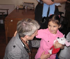 Un adulte accroupi auprès d'un enfant.