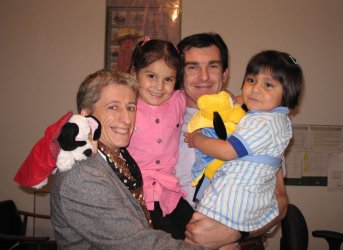 Deux adultes et deux enfants dans les bras.