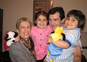 Deux adultes et deux enfants dans les bras.