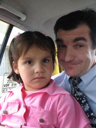 Un enfant dans les bras d'un adulte dans une voiture.