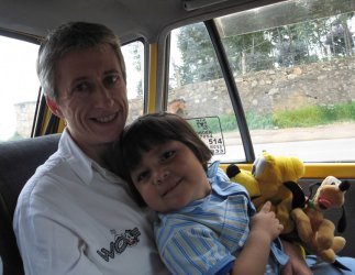 Un enfant dans les bras d'un adulte dans une voiture.