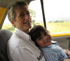 Un enfant dans les bras d'un adulte dans une voiture.