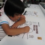 Un enfant dessine sur une table.