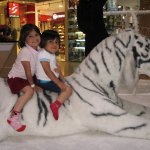 Deux enfants sont assis sur un tigre de décor de Noël.