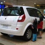 Deux enfants dessinent sur une voiture blanche.