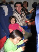 Assis dans l'avion, deux enfants et un homme.