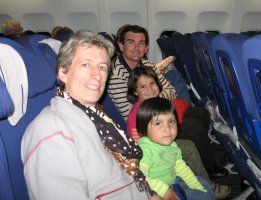 Une femme, deux enfants et un homme, assis dans l'avion.