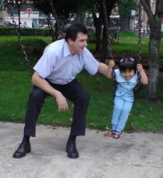 Une homme et un enfant sur une balançoire.