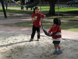 Deux enfants se tiennent debout auprès de balançoires.