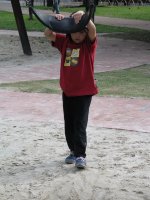 Un enfant tient le siège de la balançoire en hauteur.