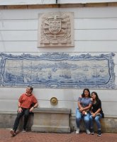 3 personnes assis devant un paysage en mosaïque.