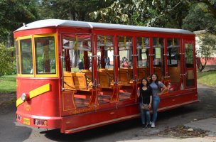 2 femmes se tenant debout devant un wagon rouge.
