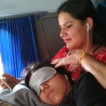 2 femmes dans un bus, l'une lit, l'autre se repose, la tête posée sur les genoux de la première.
