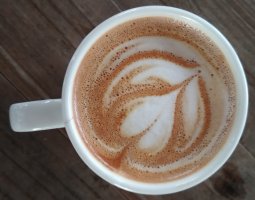 Dessus d'une tasse remplie de café avec un dessin en forme de fleur.