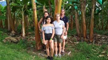 4 personnes posant devant des bananiers.
