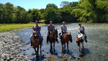 4 personnes à cheval, les pieds dans l'eau.