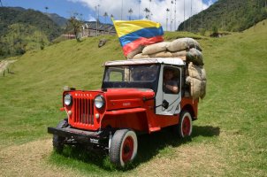Homme assis au volant d'une jeep rouge.