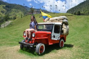 Femme assise sur le capot d'une jeep rouge.