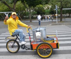Marchand circulant avec son vélo cargo.