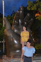 2 femmes devant la statue de Botero représentant une main.