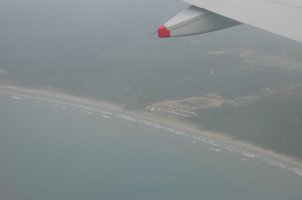 Aile d'avion avec vue sur la côte.