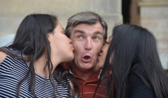 Portraits d'un homme et de 2 femmes : les femmes font une bise sur la joue de l'homme.