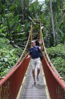 Homme traversant un pont suspendu.