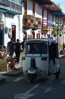 Véhicule à 3 roues circulant dans la rue.