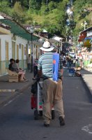 Homme poussant son chariot dans une rue.