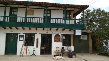 Façade de maison avec des objets disposés devant et un chien allongé sur le sol.