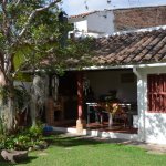 Véranda abritée de maison donnant sur un petit jardin.
