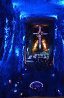 Croix illuminée en bleue dans un couloir de grotte.
