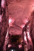 Allée de grotte illuminée en rouge.
