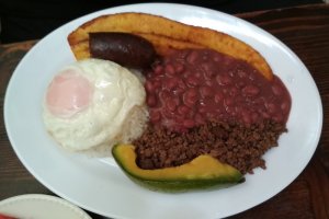 Assiette composée d'un oeuf, de haricots rouges, de viande hachée, d'une tranche d'avocat et d'une banane.