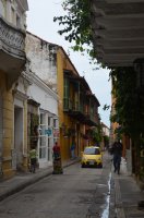 Ruelle dans laquelle circule un taxi jaune.