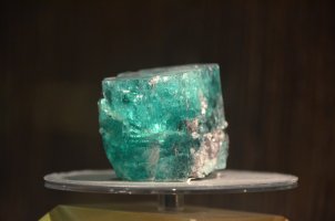 Bloc d'émeraude posé sur un socle rond.