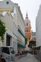 Rue bordée de maisons avec une église au fond.