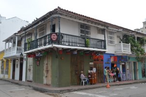 Maison avec son balcon en bois faisant le coin de la rue.