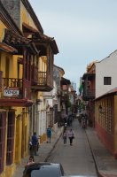 Ruelle avec balcons. Des personnes s'y promènent.
