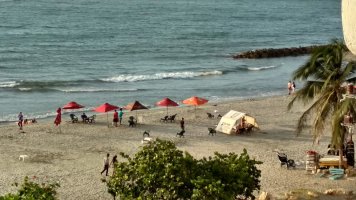Plage avec des parasols rouges et marrons.