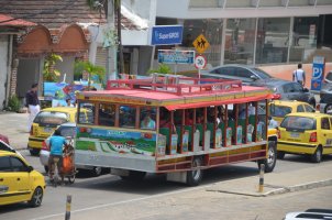 Bus de tourisme et voitures dans une rue.